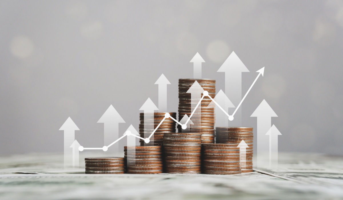 Stacked coins with an upward line graph overlayed on top