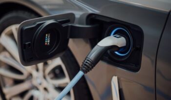 A electric car with a charger plugged into it|john cameron unsplash