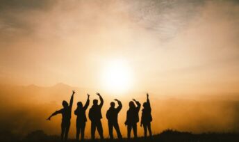 A group of teenage standing in front of the sunset