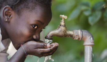 African child drinking water from tap