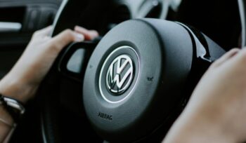 Hands on a steering wheel with Volkswagen logo|alexander raissis unsplash