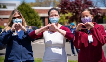 Healthcare workers making heart sign with hands