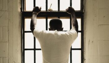 Man holding on to prison bars|hedi benyounes G gOhJeCpMg unsplash