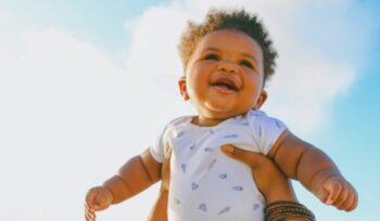 Smiling baby being held in the air