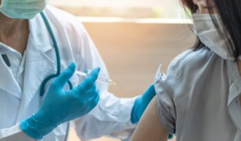 Young woman being injected with a vaccine