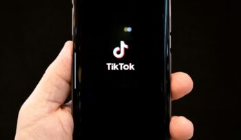 Someone holding a phone opening the TikTok app