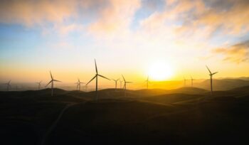 Wind turbines with rising sun in background